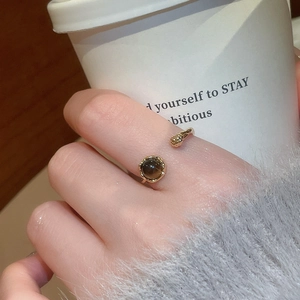 Detail of 18k gold plated open ring with tiger eye stone worn on finger