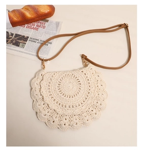 Detail of crochet crossbody bag with scalloped edges and brown leather strap