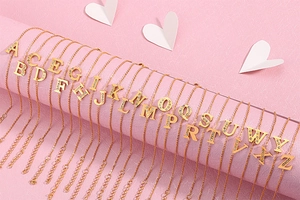 Macro detail of initial letter pendants with sparkling rhinestones in gold finish