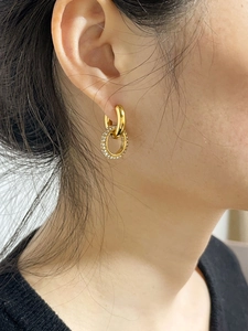 Détail de boucles d'oreilles double anneau plaqué or 18K avec zircons scintillants