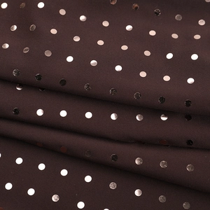 Detailed macro view of chocolate brown fabric with shiny metallic dot patterns