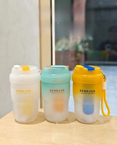 Detailed view of three frosted plastic portable water cups with leak-proof lids and handles