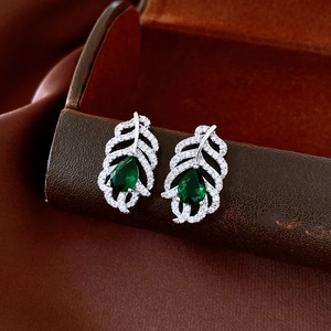 Macro shot of leaf earrings with green pear-cut stones and cubic zirconia inlay
