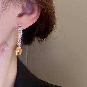 Vue macro de boucles d'oreilles dorées avec pierres en zircon champagne et cristaux