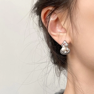 Close-up of model wearing silver hollow gourd earrings with pearls and rhinestones