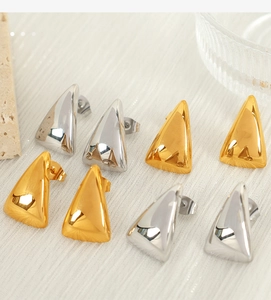 Detailed view of geometric triangle stud earrings in polished gold and silver finishes