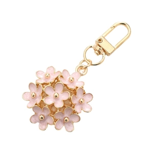 Sweet pink floral keychain with golden lobster clasp and petal charms on white background