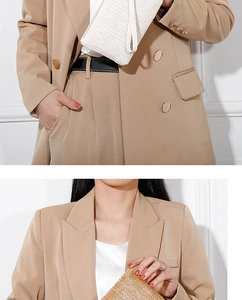 Close-up of double-breasted camel blazer featuring metallic buttons and woven texture bag