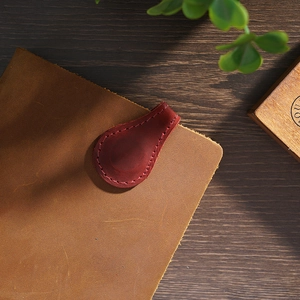Handmade reddish-brown crazy horse leather magnetic bookmark on a vintage notebook cover