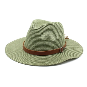 Close-up of sage green woven Panama hat with brown leather band and silver buckle