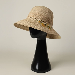 Close-up of fine raffia weave and floral embroidery on this wide brim sun hat
