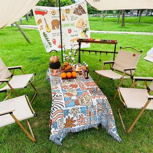 Bohemian outdoor camping blanket with vintage ethnic patterns and tassels on grass