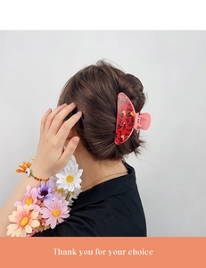 Pink heart hair claw clip shown on bun hairstyle for elegant hair styling
