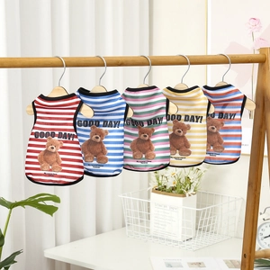 Breathable mesh pet vests with cute bear print hanging on a wooden rack for summer