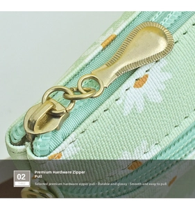 Macro shot of gold teardrop zipper pull and mint green daisy print fabric texture