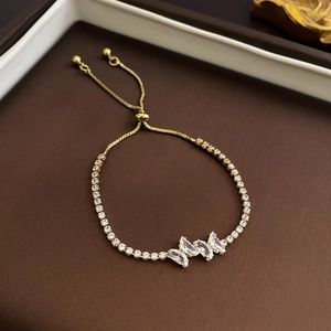 Detail of adjustable gold-tone tennis bracelet with a sparkling zircon butterfly motif