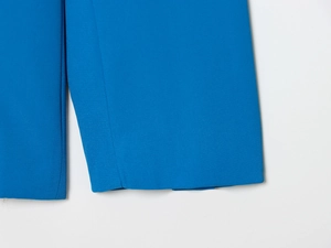 Gros plan sur la texture du tissu en sergé bleu et les finitions de couture professionnelles