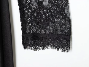 Detailed macro view showing delicate black eyelash lace and silk fabric texture on cuff