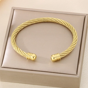 Close-up of twisted cable gold bracelet with ball ends in a champagne jewelry box