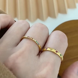 Gold titanium steel rainbow pavé rings stacked on finger with vintage star engraving