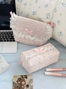 Detailed view of pink plaid quilted makeup bags with lace trim and bow accents
