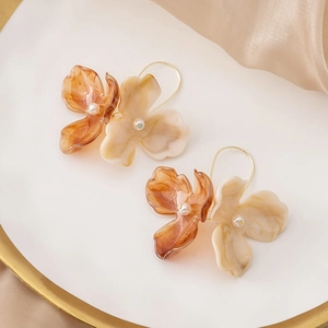 Vintage floral pearl drop earrings in amber and beige tones on a white silk background