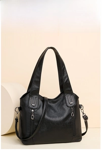 Detail of black faux leather tote showing vintage lychee texture and silver hardware