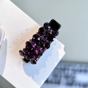 Gros plan d'une pince à cheveux rectangulaire violette avec des détails en strass