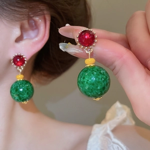 Detail of vintage round resin drop earrings with red stone and green textured bead