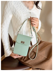 Detail of mint green lychee leather phone bag with gold twist lock and adjustable strap