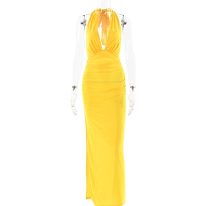 Detail of yellow halter neck maxi dress featuring pleated waist and side slit detail
