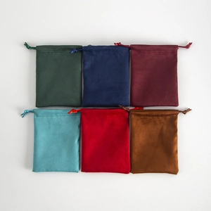 Detailed view of suede jewelry drawstring pouches in various elegant colors flat lay
