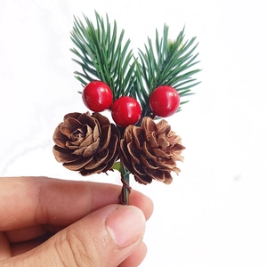 Detailed view of mini Christmas pine pick with red berries and brown pinecone decor