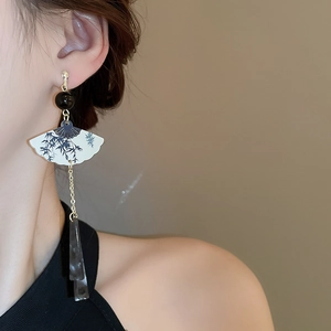 Détail de la boucle d'oreille éventail avec motif bambou et longs pompons