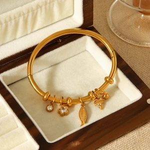Détail du bracelet en acier inoxydable plaqué or 18k avec breloques étoile et palmier