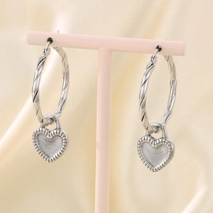 Macro view of silver heart hoop earrings with grey enamel on a soft silk background