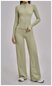 Detail showing the light green high-waisted wide-leg sweatpants with a premium matte texture