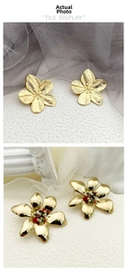Close-up of gold flower earrings with textured and polished finishes and colorful beads