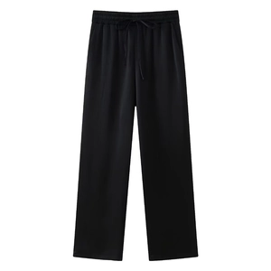 Detail einer schwarzen Hose mit weitem Bein, vertikaler Rippstruktur und Kordelzugbund