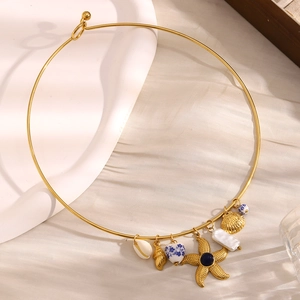 Detailed view of gold choker with sea shell, starfish and baroque pearl pendants