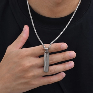 Close-up of geometric silver stainless steel bar pendant necklace with V-shape engraving