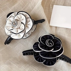 Detail shot of camellia flower hair scrunchies in black and white with contrast piping