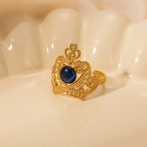 Macro detail of crown ring in gold with blue stone on decorative shell plate