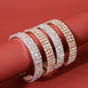 Macro shot of double-row rhinestone bracelets in gold and silver on red display
