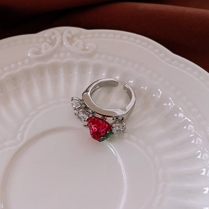 Detailed macro view of a sweet strawberry ring with red enamel and silver adjustable band