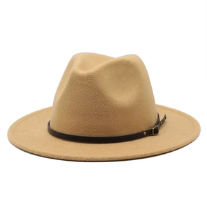 Detail of camel wool fedora hat featuring a black leather band and gold buckle
