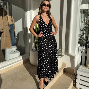 Detail of a vintage-style black and white polka dot halter dress with a deep V-neckline