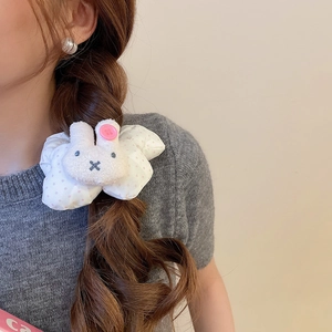 Detail of cute plush bunny hair tie with polka dots pattern on model's hair