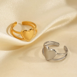 Bagues cœurs dorées et argentées à anneau ouvert sur un élégant fond en satin beige doux