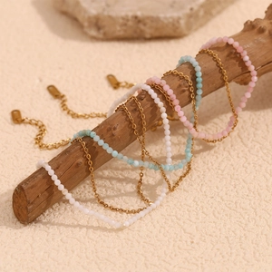 Close-up of double-layer stainless steel anklets with colorful beads on a branch